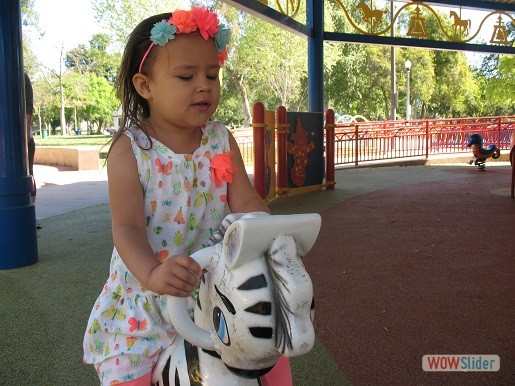 a little girl is on the rocking horse
